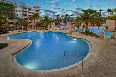 a pool at a resort with palm trees and buildings at Marriott Grande Vista Luxury Studio in Orlando