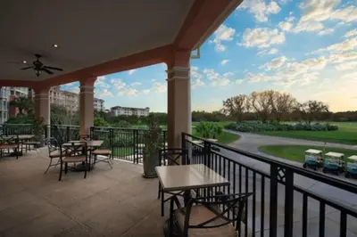 a patio with tables and chairs on a balcony at Marriott Grande Vista Luxury 1BD villa sleeps 4 in Orlando