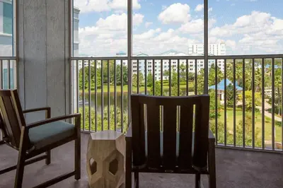 two chairs and a table in front of a balcony at Take the Family to Orlando in this great 2BD in a resort setting with tons of amenities in Orlando