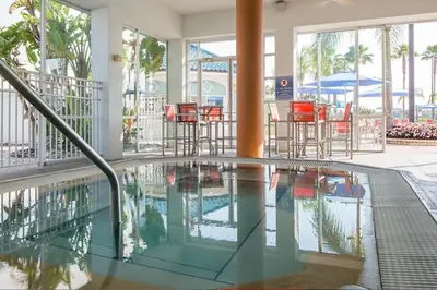 a swimming pool with chairs and tables in a building at Take the Family to Orlando in this great 2BD in a resort setting with tons of amenities in Orlando