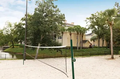 a volleyball net in the sand in front of a house at Relax after the Orlando parks in this 1BD resort condo with pools, restaurants, activities etc in Orlando