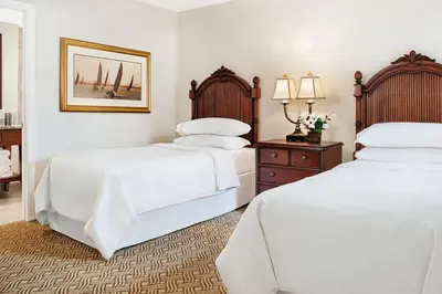 two beds in a bedroom with white sheets at Have fun in this 2BD condo in a resort setting with close access to Orlando parks in Orlando