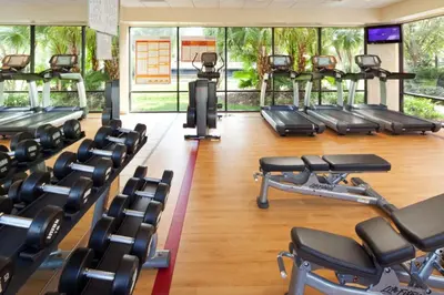 a gym with several rows of cardio machines at Family fun in this 2BD condo with multiple pools, mini golf, restaurants etc onsite in Orlando