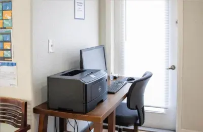 a desk with a computer and a printer on it at Diamond Barefootn Resort 2BD in Orlando