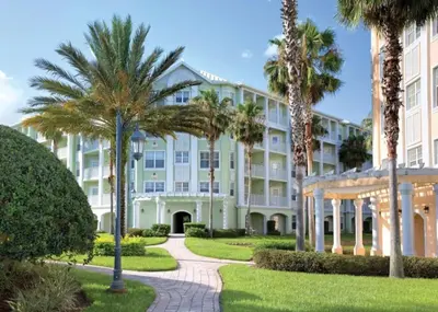 a large white building with palm trees and a pathway at WorldMark Kingstown Reef - Studio Sleeps up to 2 in Orlando