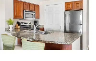a kitchen with a sink and a stainless steel refrigerator at Marriott Grande Vista 2BD villa sleeps 8 in Orlando