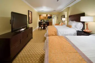 a hotel room with two beds and a flat screen tv at Studio Apt in Orlando resort onsite pools, golf, arcades, cabanas etc. in Orlando