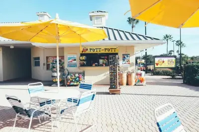 a table and chairs with yellow umbrellas in front of a store at Studio Apt in Orlando resort onsite pools, golf, arcades, cabanas etc. in Orlando