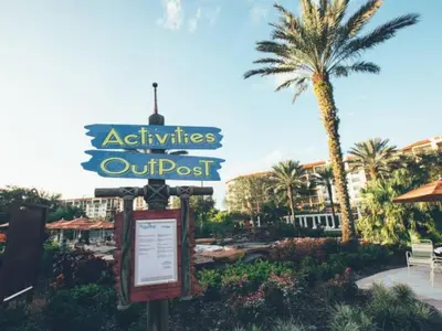 a sign in front of a resort with a palm tree at Near Disney 1BD vacation condo in beautiful resort with lots of amenities in Orlando