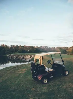 a golf cart parked in the grass on a field at Enjoy Orlando Family Getaway in 2BD condo with lots of onsite activities in Orlando