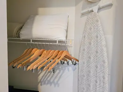 a closet with a rack of shirts and a pillow at 1 Bedroom - Grand Suite 5 min to Universal, I-drive & Outlets in Orlando