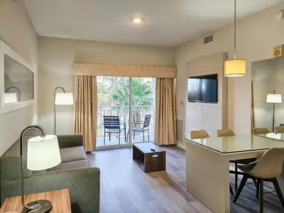 a living room with a couch and a table at 1 Bedroom - Grand Suite 5 min to Universal, I-drive & Outlets in Orlando