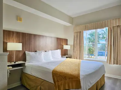 a hotel room with a large bed with a window at Double King Bed Suite, 5 Min from Universal, I-Drive & Outlets in Orlando