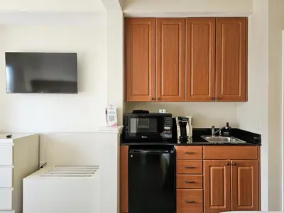 a kitchen with a black refrigerator and a microwave at Double King Bed Suite, 5 Min from Universal, I-Drive & Outlets in Orlando