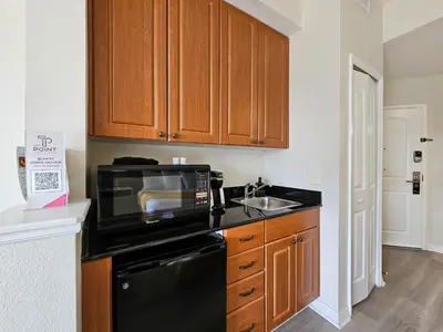 a kitchen with a black microwave and a sink at Double King Bed Suite, 5 Min from Universal, I-Drive & Outlets in Orlando