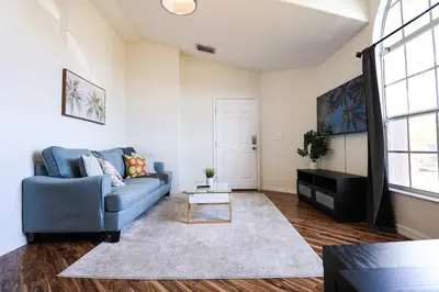 a living room with a blue couch and a table at New APT 15Min Drive Disney and Airport - Parks KingBed Pets in Kissimmee