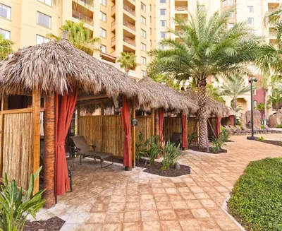 a row of huts with palm trees and a building at Beautiful Resort in Bonnet Creek 1BD Deluxe near Walt Disney World in Orlando