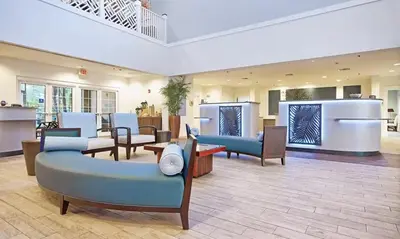 a lobby with couches and chairs in a building at Beautiful Hotel of Cypress Palms 1BD near Kissimmee Lakefornt Park in Kissimmee
