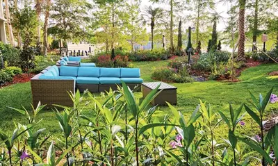 a blue couch sitting in the middle of a garden at Beautiful Hotel of Cypress Palms 2BD in Kissimmee