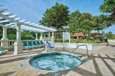 a hot tub on a patio with chairs and a pergola at Beautiful Resort in Star Island 2BD near at Lake Cecile in Kissimmee