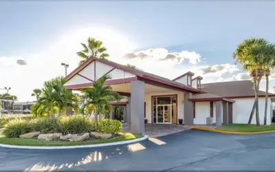 a house with palm trees and a driveway at Diamond - Orbit One Vacation Villas- 2BD in Orlando