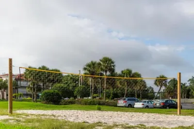 a volleyball net in a park with parked cars at Diamond - Orbit One Vacation Villas- 2BD in Orlando