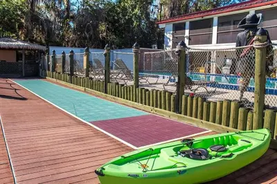 a green boat on a mat next to a pool at Diamond Bryans Spanish Cove 2BD in Orlando