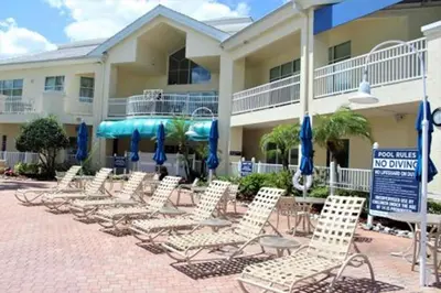 a group of chairs and umbrellas in front of a hotel at Diamond - Cypress Pointe Resort - St in Orlando