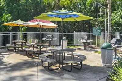a group of picnic tables with umbrellas at Diamond - Cypress Pointe Resort - St in Orlando