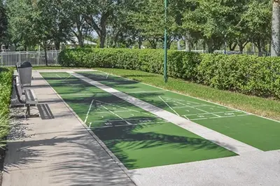 a green tennis court with a bench in a park at Diamond - Cypress Pointe Resort - St in Orlando
