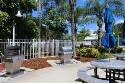 a patio with two tables and an umbrella at Diamond - Cypress Pointe Resort - 2BD in Orlando