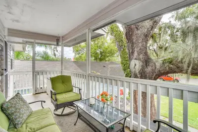 a balcony with a table and a chair and a tree at Half-Mi to Riverwalk Charming Sanford Retreat! in Sanford