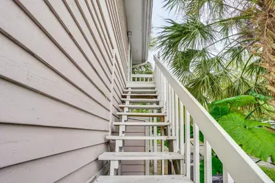 a staircase leading up to a house with palm trees at Half-Mi to Riverwalk Charming Sanford Retreat! in Sanford