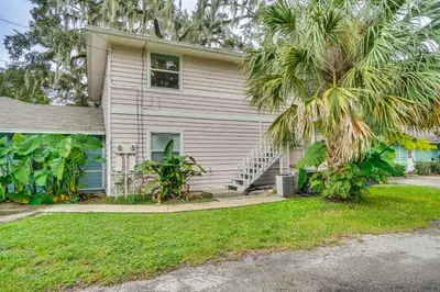 a house with a palm tree in front of it at Half-Mi to Riverwalk Charming Sanford Retreat! in Sanford