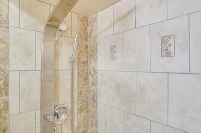 a bathroom with a shower with marble tiles at Half-Mi to Riverwalk Charming Sanford Retreat! in Sanford