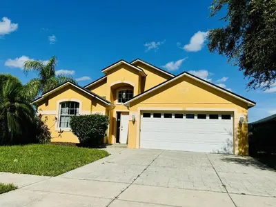 a yellow house with a garage at 43 Vacation Home With Private Pool Located At Formosa Gardens!! in Orlando