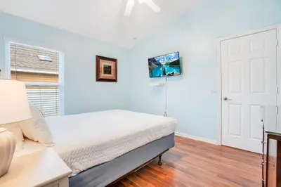 a white bedroom with a bed and a window at Relaxing Retreat with Pool and Movie Theater in Orlando