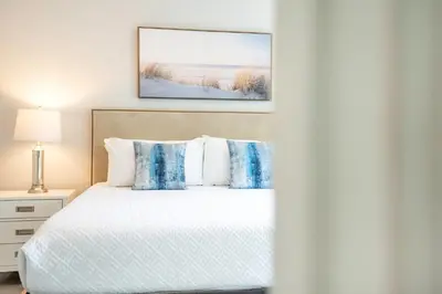 a bedroom with a white bed with blue pillows at Stylish Villa Near Disney & Universal in Kissimmee