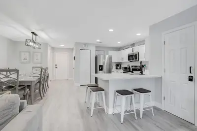 a kitchen and dining room with a counter and stools at Stylish Villa Near Disney & Universal in Kissimmee