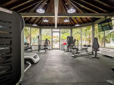 a gym with several treadmills and machines in a room at Orlando 1BR Disney Themed Vacation with pool view Next to Disney in Kissimmee