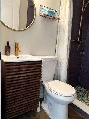 a bathroom with a toilet and a sink and a mirror at Downtown Groovy Studio in Orlando