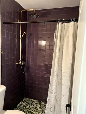 a bathroom with a shower with a white shower curtain at Downtown Groovy Studio in Orlando