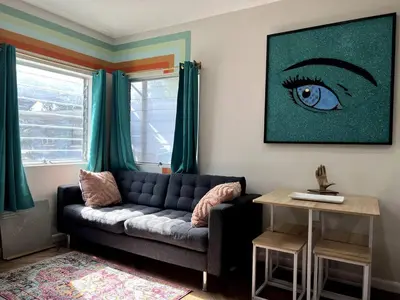 a living room with a couch and an eye painting at Downtown Groovy Studio in Orlando