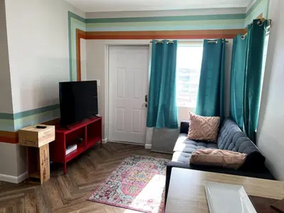 a living room with a couch and a flat screen tv at Downtown Groovy Studio in Orlando