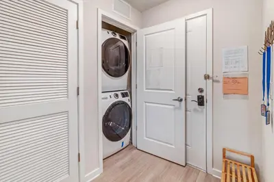 a laundry room with two washing machines and a door at Modern Resort 2BR near Icon park, Convention center and NEW Epic Universe in Orlando