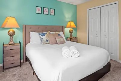 a bedroom with a large white bed with two lamps at Terra Verde Townhouse with Patio in Kissimmee
