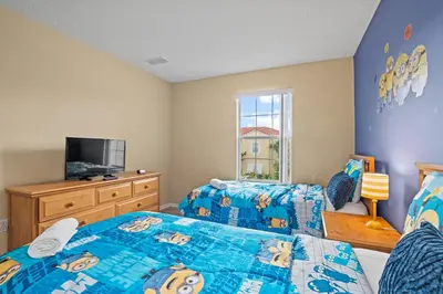 a bedroom with two beds and a flat screen tv at Terra Verde Townhouse with Patio in Kissimmee