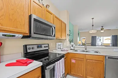 a kitchen with a microwave and a stove top oven at Terra Verde Townhouse with Patio in Kissimmee