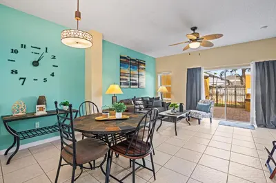 a dining room and living room with a clock on the wall at Terra Verde Townhouse with Patio in Kissimmee