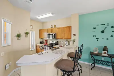 a kitchen with a counter with chairs and a table at Terra Verde Townhouse with Patio in Kissimmee